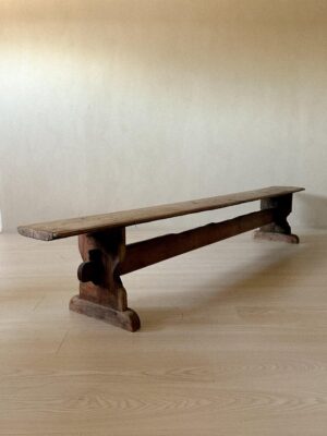Raw wooden bench under natural light with shadow play