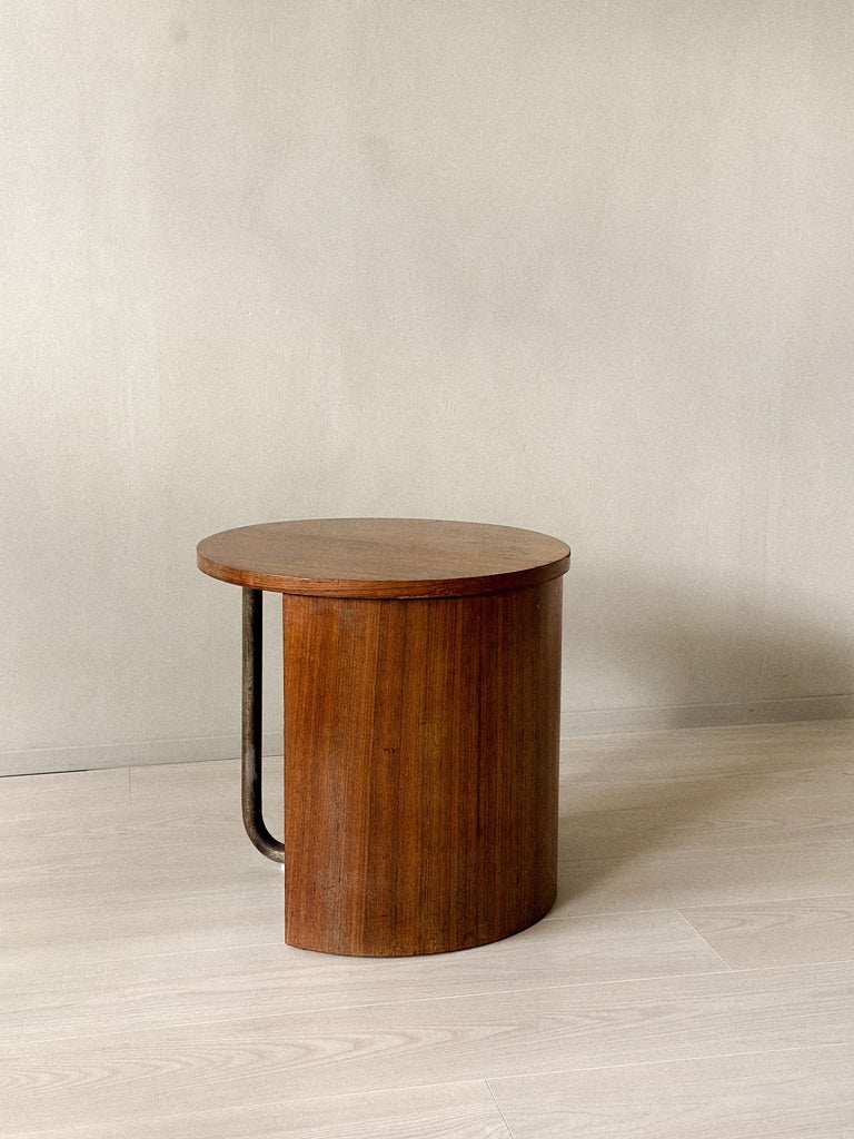 Round oak side table with curved wood and patinated metal base