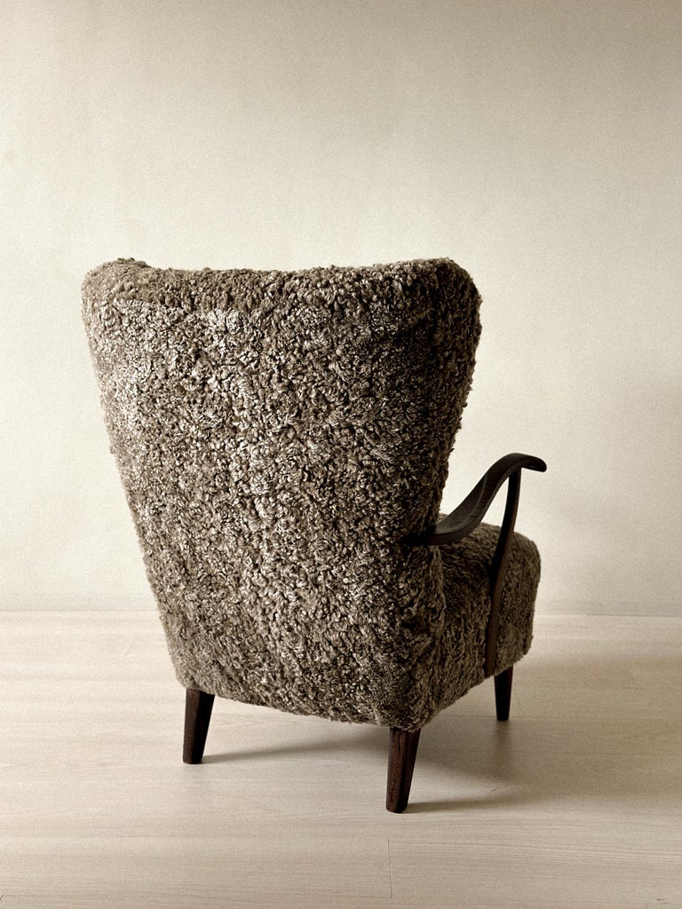 Sculptural Danish armchair with winged back and natural materials