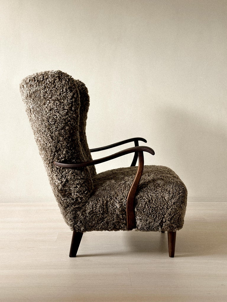 Organic-shaped wing chair with premium sheepskin and sculpted wood
