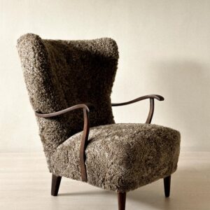 Danish wing back chair with dark stained wood and sheepskin upholstery