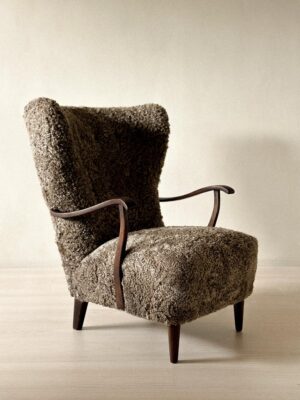 Danish wing back chair with dark stained wood and sheepskin upholstery