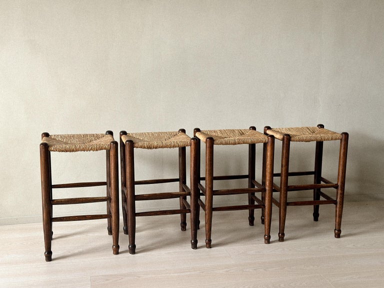 Set of four mid-century French bar stools with rush seats and wooden frames