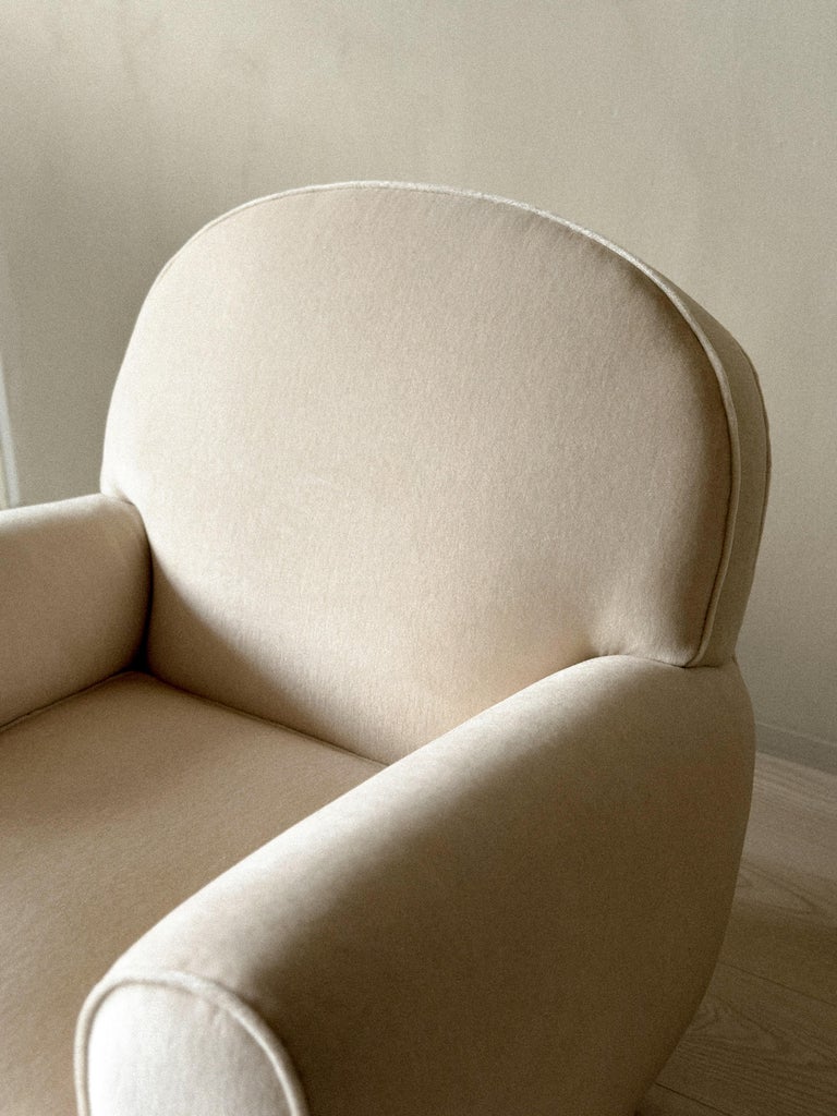 Low sculptural armchair with rounded oak feet