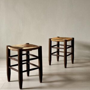Back-to-back Charlotte Perriand stools with woven tops