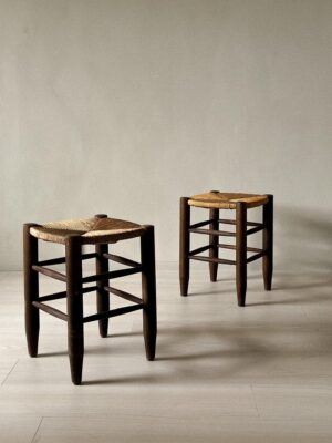 Back-to-back Charlotte Perriand stools with woven tops