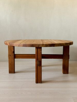 Side profile of round pine side table on neutral background