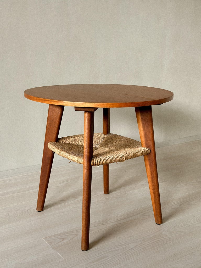 Side view of mid-century Danish table with woven lower shelf