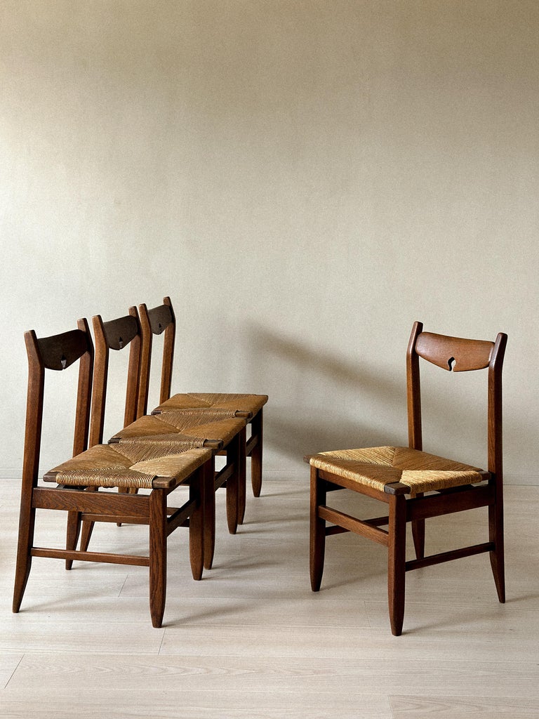 Set of four oak dining chairs with rush seats by Guillerme et Chambron
