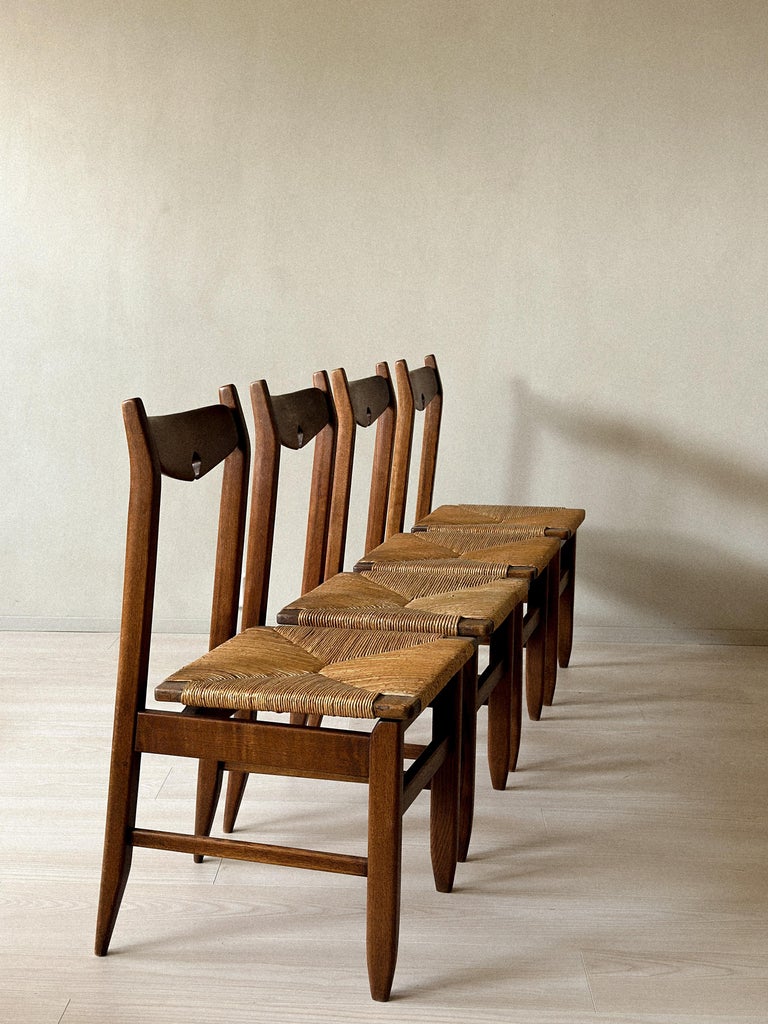 Side view of French oak dining chairs with rush seats