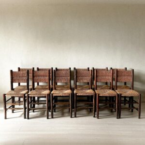 Grouping of 12 rush dining chairs arranged in a row