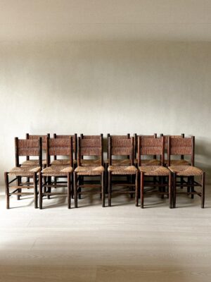 Grouping of 12 rush dining chairs arranged in a row
