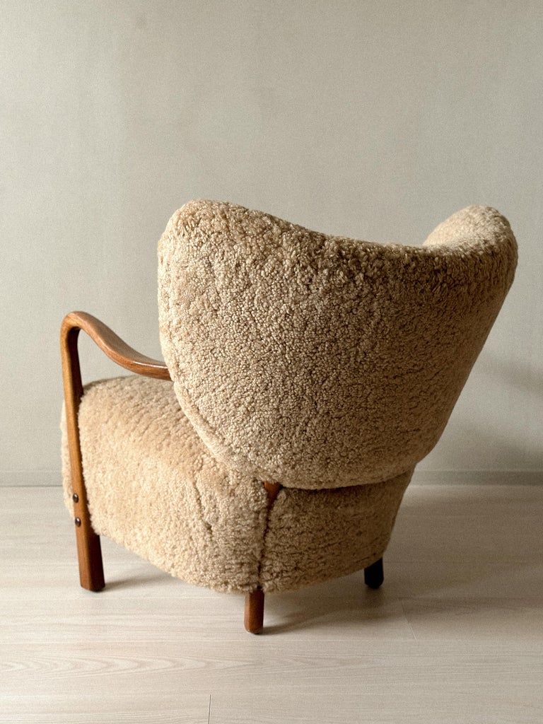 Side view of sculptural Danish armchairs with shearling