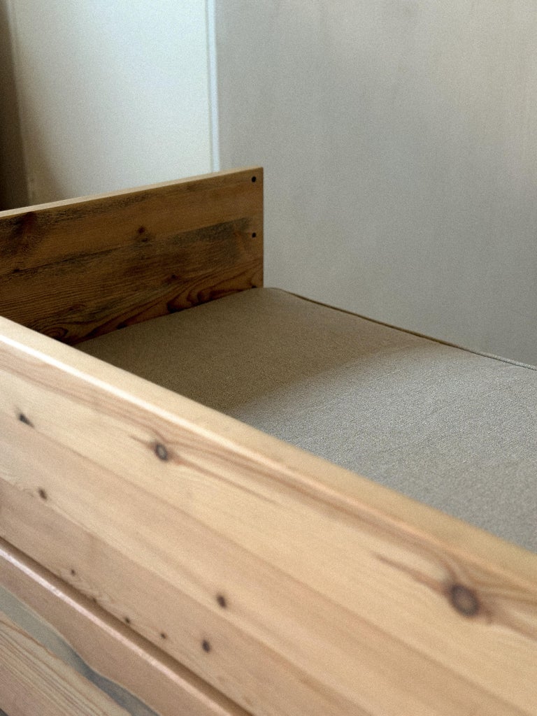 Low modern daybed in warm pine with textured cushion