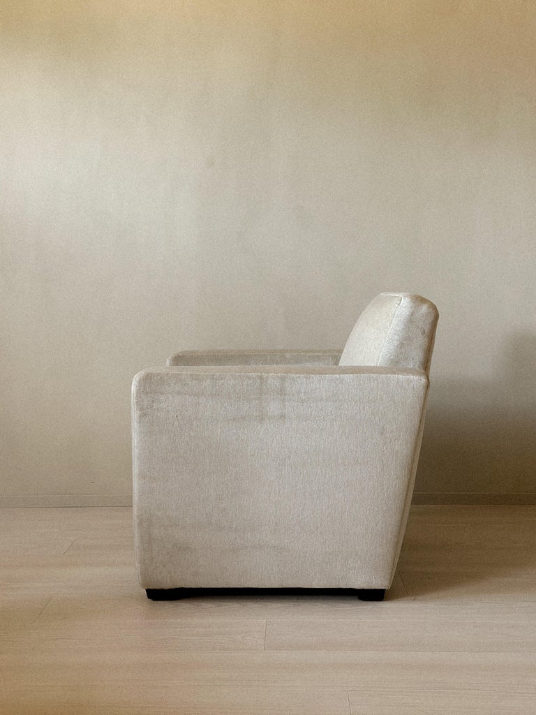 Side profile of low Danish club chair with wooden feet