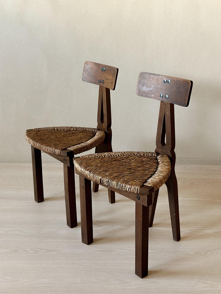 Side profile of low wooden chairs with woven rush seats