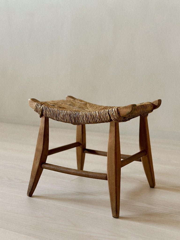 Minimalist stool with wooden legs and woven top