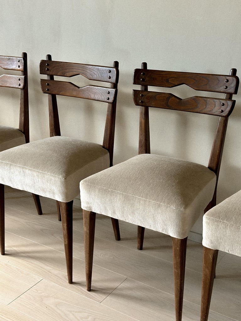 Three-quarter view of mid-century dining chairs with dark finish