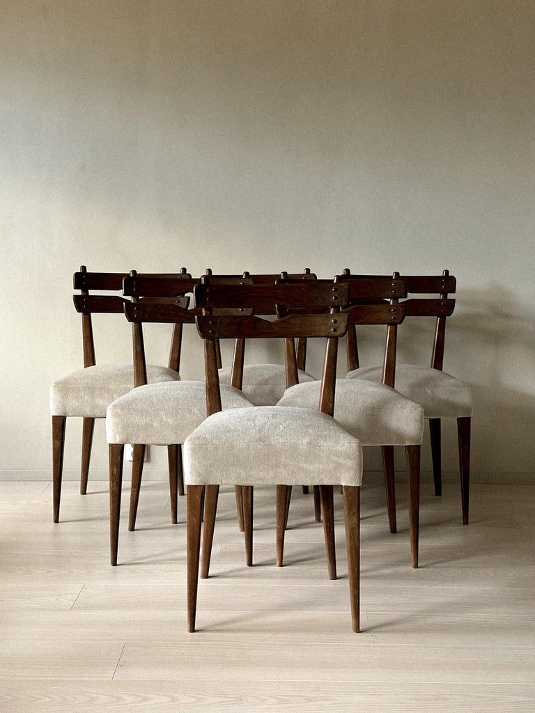 Front view of mid-century dining chairs in dark wood and fabric seats
